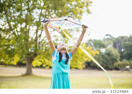 Girl holding a kite in park Girl holding a kite in park 31524884