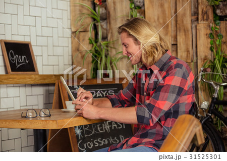 Man using a tablet sitting 31525301