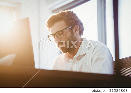 Business man working on his computer Business man working on his computer 31525363