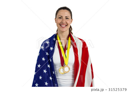 Athlete posing with american flag and gold medals around his neck 31525379