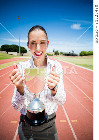 Portrait of happy businesswoman holding a trophy Portrait of happy businesswoman holding a trophy 31525430