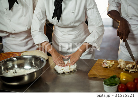 Mid section of head chef making pizza dough 31525521