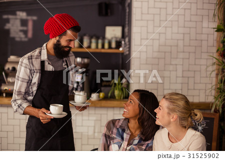 Waiter serving coffee and interacting with customers 31525902