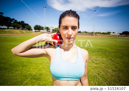 Portrait of female athlete preparing to throw shot put ball Portrait of female athlete preparing to throw shot put ball 31526107