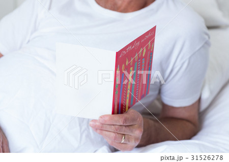 Senior man holding birthday greeting card 31526278