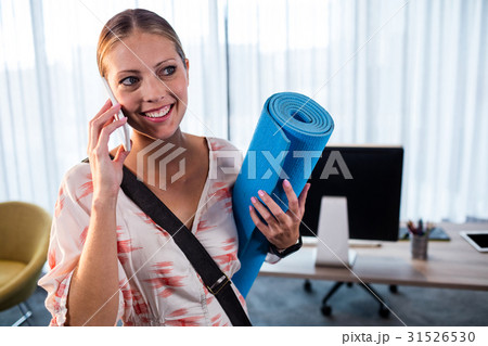 Casual business woman holding yoga mat Casual business woman holding yoga mat 31526530