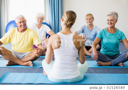 Instructor performing yoga with seniors Instructor performing yoga with seniors 31526589