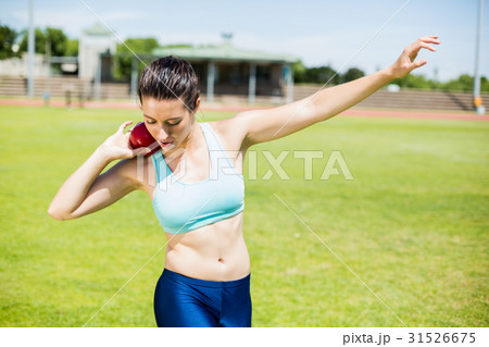 Female athlete preparing to throw shot put ball 31526675