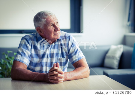 Worried senior man sitting in living room 31526780
