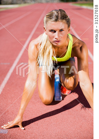 Female athlete ready to run on running track 31527038