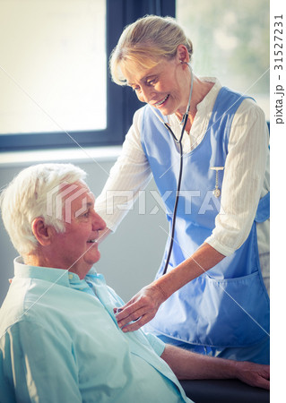 Female doctor checking heartbeat of senior man 31527231