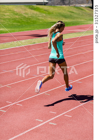 Female athlete running on the racing track 31527355