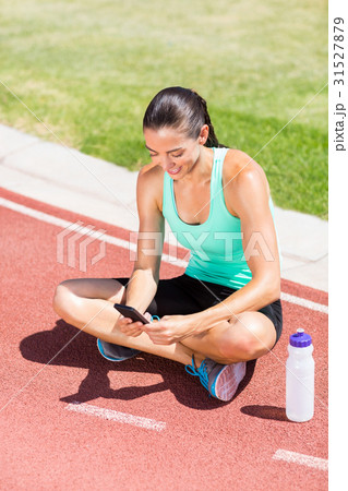 Happy female athlete using mobile phone 31527879