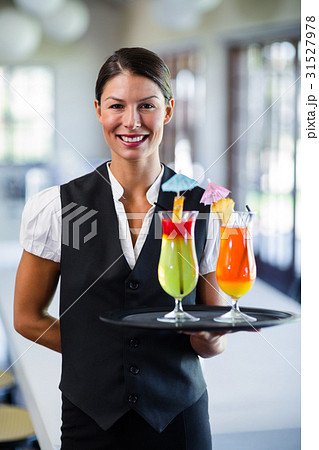 Portrait of smiling waitress serving cocktail Portrait of smiling waitress serving cocktail 31527978