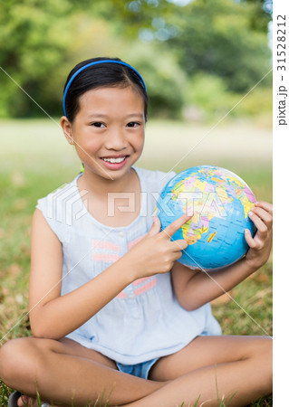 Portrait of smiling girl pointing at globe 31528212