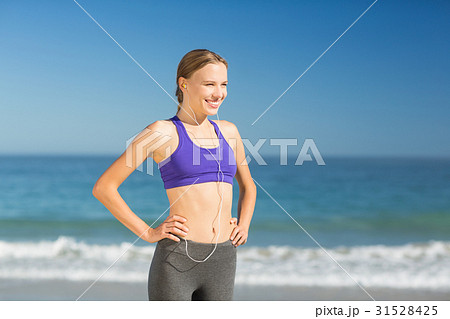 Beautiful young woman listening music while exercising Beautiful young woman listening music while exercising 31528425