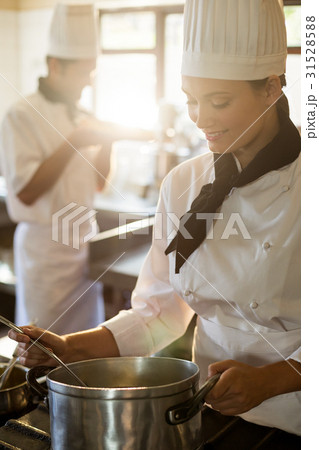 Happy head chef cooking at stove Happy head chef cooking at stove 31528588