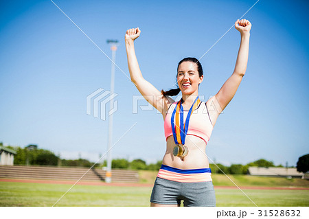 Excited female athlete with gold medals around her neck 31528632