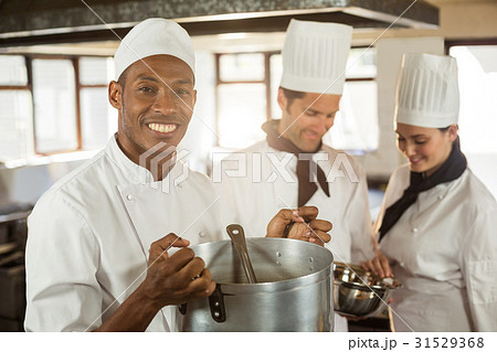 Portrait of smiling chef holding a cooking pot Portrait of smiling chef holding a cooking pot 31529368