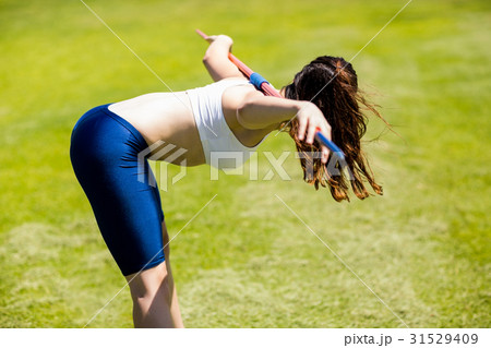 Female athlete carrying javelin on her shoulder 31529409