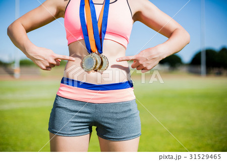 Mid section of female athlete with gold medals around her neck 31529465