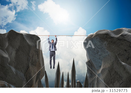 Businessman hanging on rope in danger concept 31529775
