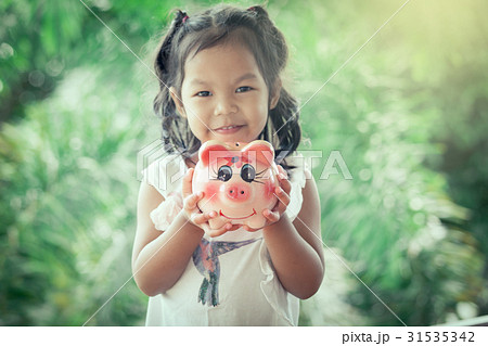 asian little girl holding Piggy Bank asian little girl holding Piggy Bank 31535342