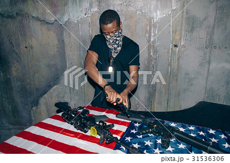 Black gun dealer checks a weapon 31536306