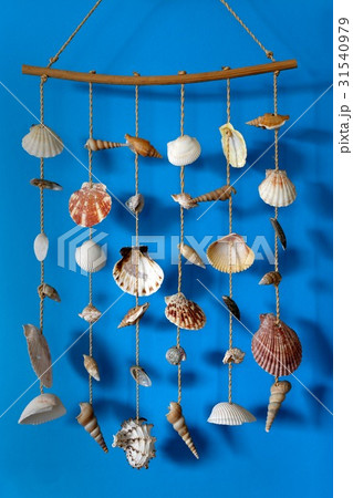 A wind chime with shells on a blue background A wind chime with shells on a blue background 31540979
