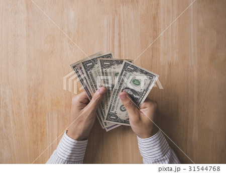 hand holding dollar on wooden table in office. 31544768