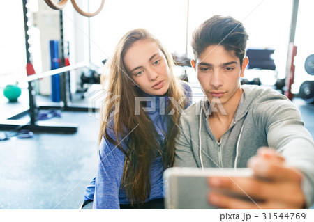 Fit couple in modern crossfit gym with smartphone. 31544769