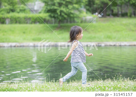 川辺を走る女の子の写真素材