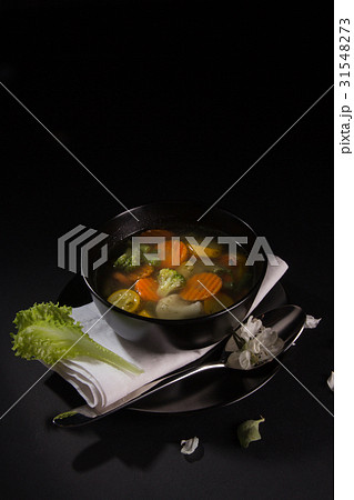 Vegetable soup in a black plate Vegetable soup in a black plate 31548273