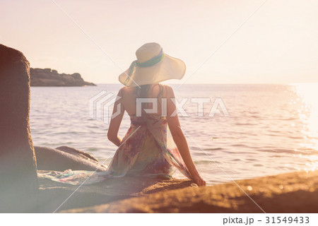 Women is sitting on a rock on the beach 31549433