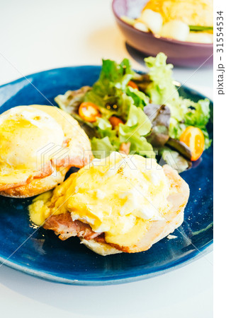 Eggs benedict with ham and sauce on top 31554534