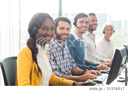 Team of colleagues working at their desk with headset 31556017
