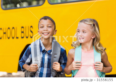 Kids standing in front of school bus 31556155