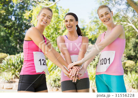 Young athlete women forming hands stack Young athlete women forming hands stack 31556228