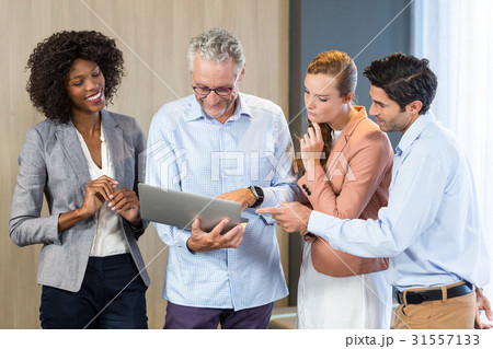Smiling business people discussing over laptop 31557133