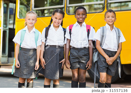 Smiling kids standing together in front of school bus Smiling kids standing together in front of school bus 31557136