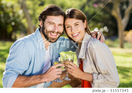 Portrait of couple toasting glasses of wine 31557345