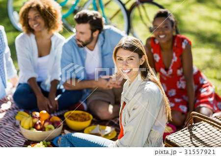 Woman sitting with her friends in park 31557921