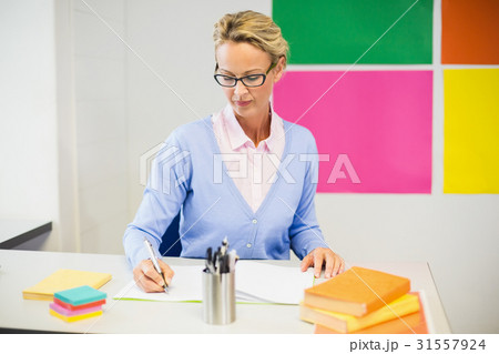 Teacher checking book in classroom Teacher checking book in classroom 31557924