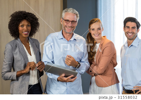 Portrait of smiling business people standing together with laptop 31558032