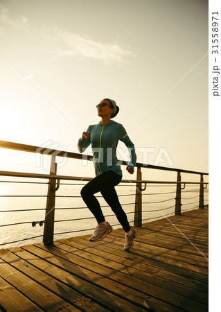 fitness woman runner running on sunrise boardwalk 31558971