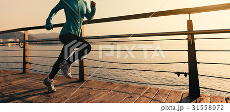 fitness woman runner running on sunrise boardwalk 31558972
