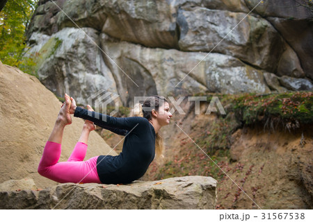 Woman is practicing yoga on the top of mountain 31567538