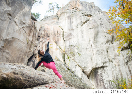 Woman is practicing yoga on the top of mountain 31567540