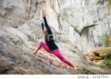 Woman is practicing yoga on the top of mountain 31567543