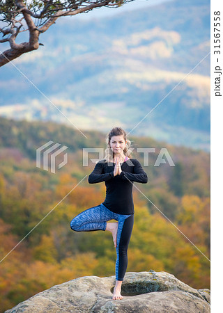 Woman is practicing yoga on the top of mountain 31567558